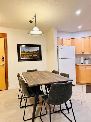 a kitchen with a dining room table and chairs at W463 Canmore 2BD 2BT, AC, MT view, Central Location in Canmore