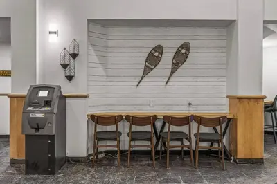 a restaurant with a bar with four chairs and a table at W463 Canmore 2BD 2BT, AC, MT view, Central Location in Canmore