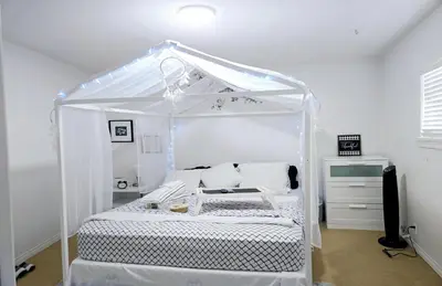 a white bed with a canopy in a room at Lovely Cozy Room! with Attached Private Bath in the Heart of Vancouver! Private Parking & Self Check-in! in Vancouver