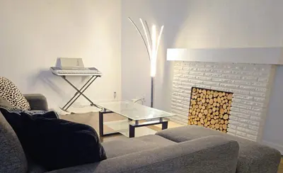 a living room with a couch and a table and a fireplace at Lovely Cozy Room! with Attached Private Bath in the Heart of Vancouver! Private Parking & Self Check-in! in Vancouver