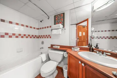 a bathroom with a tub and a toilet and a sink at Mid Century Modern - Studio w Pool & Hot Tub in Whistler
