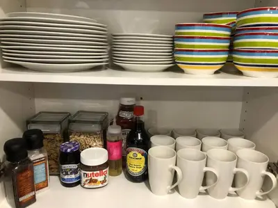 a shelf with cups and plates and other dishes at Heated pool, hot tub, 4 AC lake view bedrooms in West Kelowna