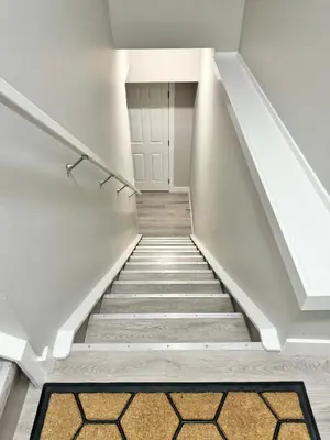 a staircase in a home with white walls and a carpet at Private Modern Retreat in the NW - 12 mins to Airport - Near Shops - Easy Banff Access in Calgary