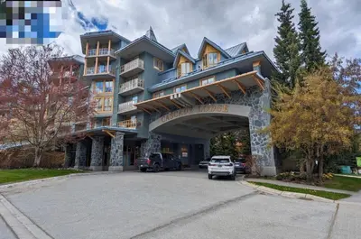 a large building with a truck parked in front of it at a fully renovated condo near village centre with MT view and close to lift in Cascade lodge in Whistler