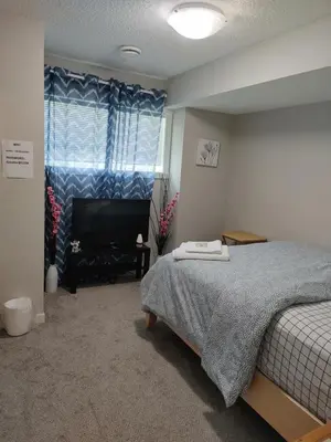 a bedroom with a bed and a television in it at Genesis Townhouse in Calgary