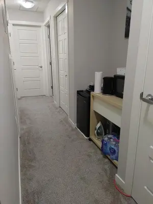 a hallway with two white doors and a desk at Genesis Townhouse in Calgary