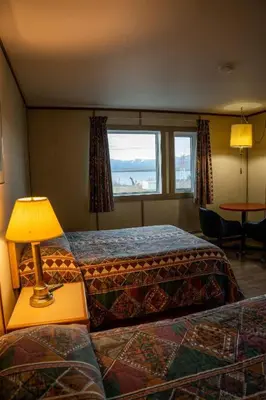 a hotel room with two beds and a lamp at Talbot Arm Motel in Destruction Bay