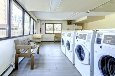 a laundry room with washing machines and a bench at Stylish DT Views at Stampede w Free Parking and AC in Calgary