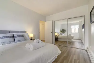 a bedroom with a large white bed with towels on it at Stylish DT Views at Stampede w Free Parking and AC in Calgary