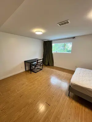 a bedroom with a bed and a desk and a window at Green House in Vancouver West in Vancouver