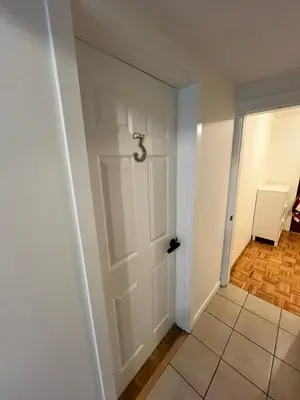 a hallway with a white door and a tile floor at Green House in Vancouver West in Vancouver