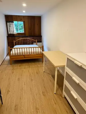 a room with a bed and a desk and a table at Green House in Vancouver West in Vancouver
