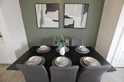 a black dining room table with chairs and a vase with flowers at Elegant Retreat with King Beds,Golf,Disney,Near WEM in Edmonton