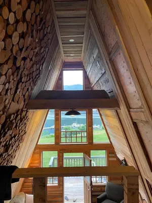 an attic view of a cabin with a large window at Shannaghs Sweet Escape in Powell River