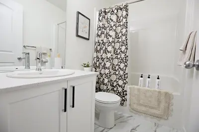 a bathroom with a sink and a toilet and a shower at Elegant Escape with King Bed, Long Stays, WEM, Disney in Edmonton