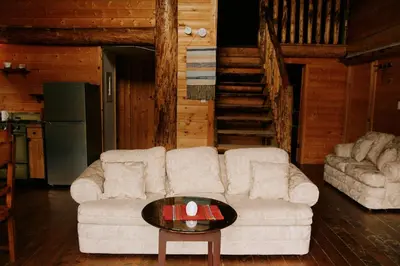 a living room with a white couch and a table at Rustic Dream Cabin at Beaverfoot in Parson