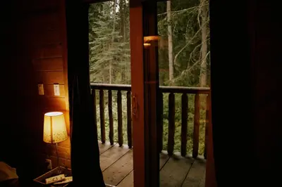 a door leading to a porch with a lamp on it at Rustic Dream Cabin at Beaverfoot in Parson