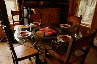 a dining room table with chairs and a glass table at Rustic Dream Cabin at Beaverfoot in Parson