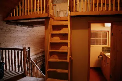 a loft bed in a room with a staircase at Rustic Dream Cabin at Beaverfoot in Parson