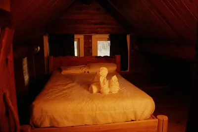 a stuffed animal sitting on a bed in a room at Rustic Woodland Cabin at Beaverfoot in Parson