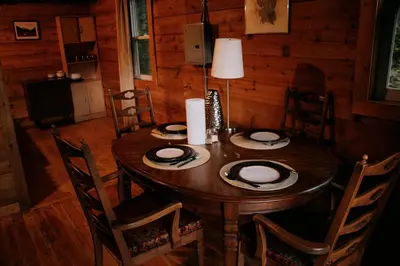 a wooden table in a room with a dining room at Rustic Woodland Cabin at Beaverfoot in Parson