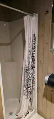a shower curtain in a bathroom next to a tub at Rustic Woodland Cabin at Beaverfoot in Parson