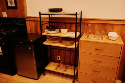 a kitchen with a shelf with plates and dishes on it at Rustic Basic Cabin at Beaverfoot in Parson