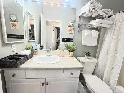 a bathroom with a sink and a toilet and a mirror at Spacious & Comfy Upper Floor 3BR Suite in Detached House in Calgary