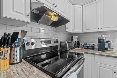 a kitchen with white cabinets and a stove top oven at Spacious & Comfy Upper Floor 3BR Suite in Detached House in Calgary