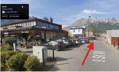 a street with cars parked in front of a building at #202 Cozy Mountain View 2 bedrooms in DT in Canmore