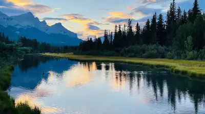 a river with trees and mountains in the background at #202 Cozy Mountain View 2 bedrooms in DT in Canmore