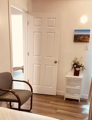 a room with a door and a chair and a table at #202 Cozy Mountain View 2 bedrooms in DT in Canmore
