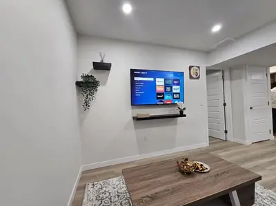 a living room with a flat screen tv on a wall at Parkside Basement Suite in Edmonton