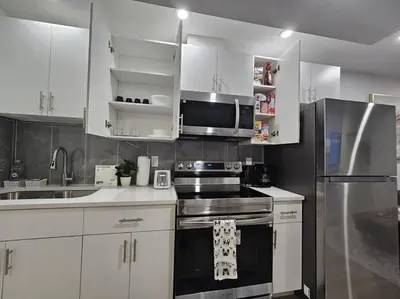 a kitchen with white cabinets and stainless steel appliances at Parkside Basement Suite in Edmonton