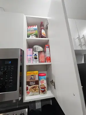 an open pantry door with food items in it at Parkside Basement Suite in Edmonton