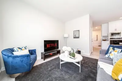 a living room with a blue couch and a table at Beautiful Elegant Home Sleeps 10, Free Parking, Central AC in Edmonton