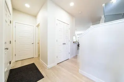a white hallway with white doors and a rug at Beautiful Elegant Home Sleeps 10, Free Parking, Central AC in Edmonton
