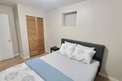 a bedroom with a bed with white sheets and pillows at Cheerful 2BR suite, onsite free parking CARS or RV in North Vancouver