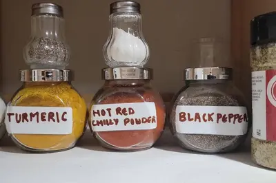 a shelf with four glass jars filled with different spices at Cheerful 2BR suite, onsite free parking CARS or RV in North Vancouver