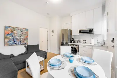 a kitchen and a living room with a table and chairs at New Bright Modern Guest Suite in Vancouver in Burnaby