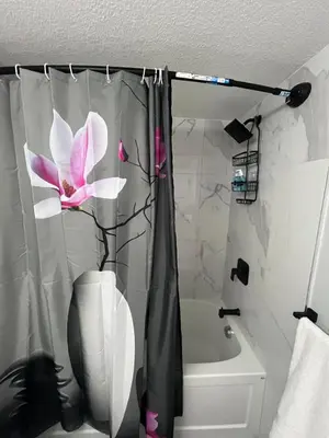 a bathroom with a shower curtain with a flower on it at Adorable Private Suite in Seton SE, Calgary in Calgary