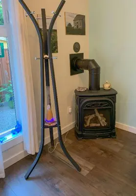 a room with a fireplace and a stove at Windslow Guest Suite at Kye Bay in Comox
