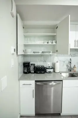 a kitchen with white cabinets and a stainless steel dishwasher at Warm getaway Perfect for 4 in Edmonton