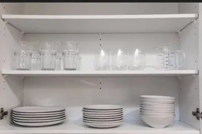 a white shelf with plates and glasses on it at Warm getaway Perfect for 4 in Edmonton