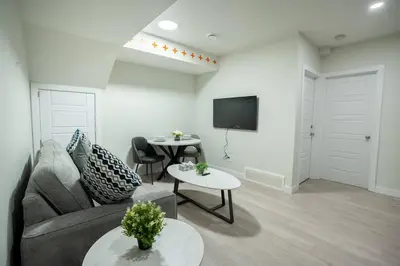 a living room with a couch and tables and a tv at Warm getaway Perfect for 4 in Edmonton