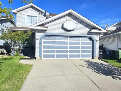 a house with a garage door in a driveway at Guest Suite in Southeast Calgary in Calgary