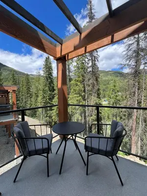 a patio with two chairs and a table on a balcony at Private Hot Tub Ski In Ski Out Sleeps 9 in Panorama