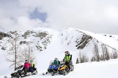a group of people riding on snowmobiles in the snow at Private Hot Tub Ski In Ski Out Sleeps 9 in Panorama