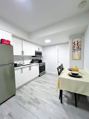 a large kitchen with a table and a refrigerator at Guest Suite in SouthWest Edmonton in Edmonton