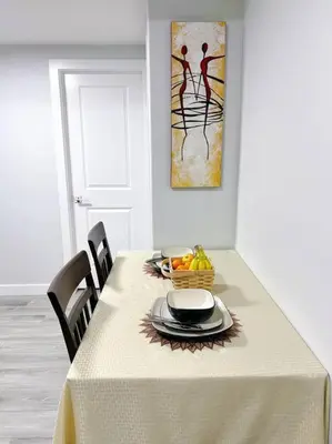 a table with a white table cloth and a bowl of fruit at Guest Suite in SouthWest Edmonton in Edmonton